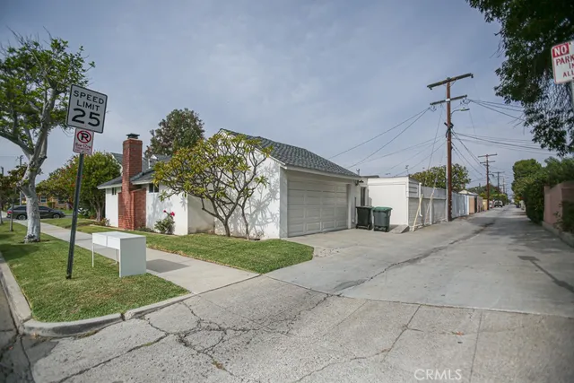 a view of a house with a yard and potted plants
