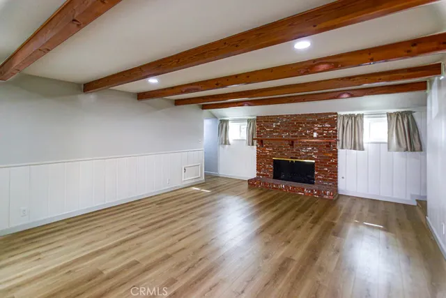 a view of a livingroom with wooden floor and a fireplace