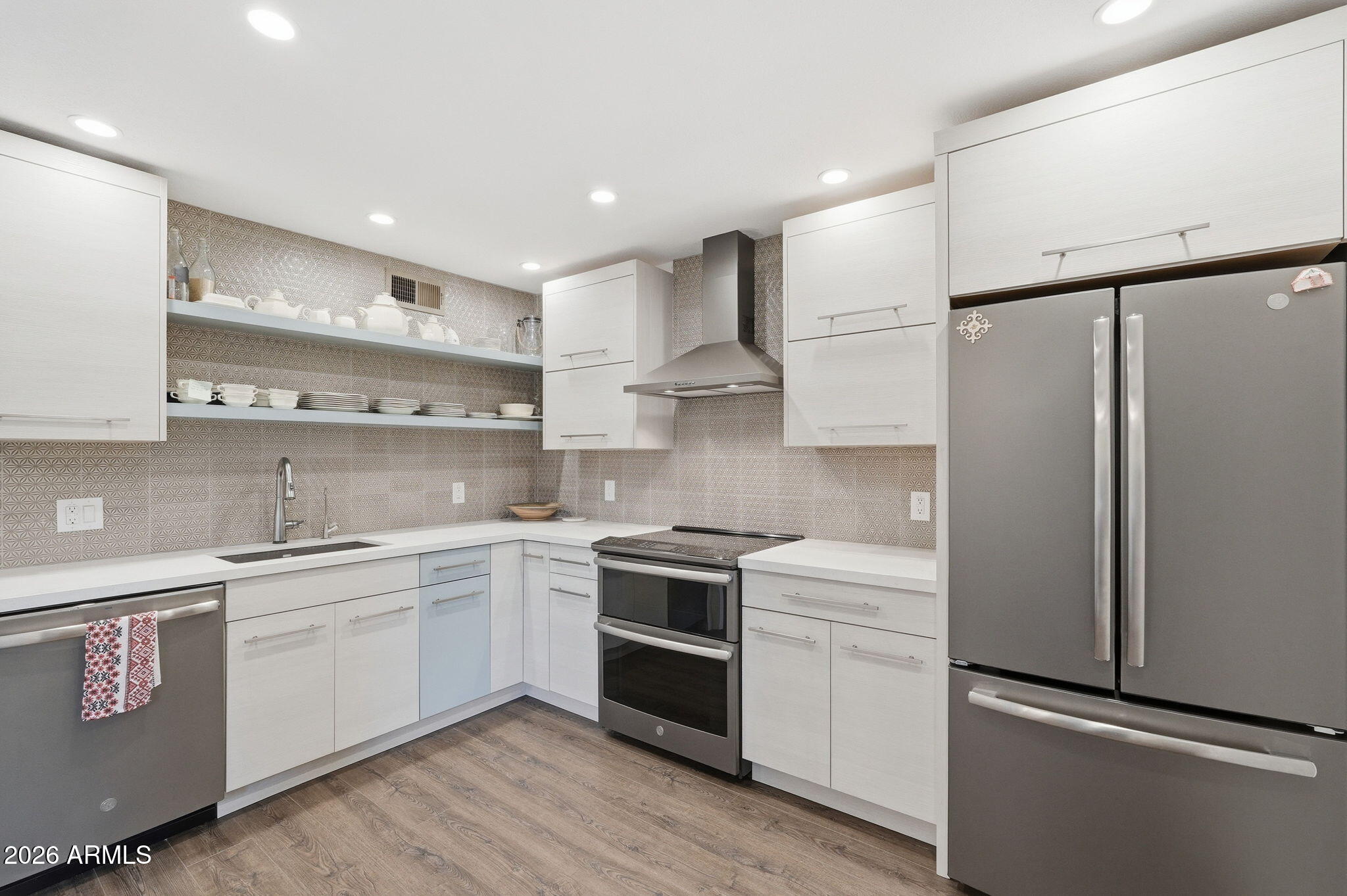 4201 East Camelback Road, Unit 34 Phoenix, AZ 85018 - Photo 4 of 19 a kitchen with stainless steel appliances white cabinets and a refrigerator