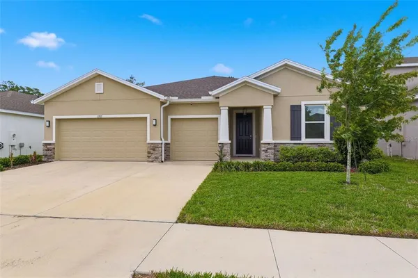 a front view of a house with a yard and garage
