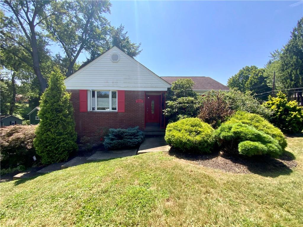 a front view of a house with a yard and potted plants