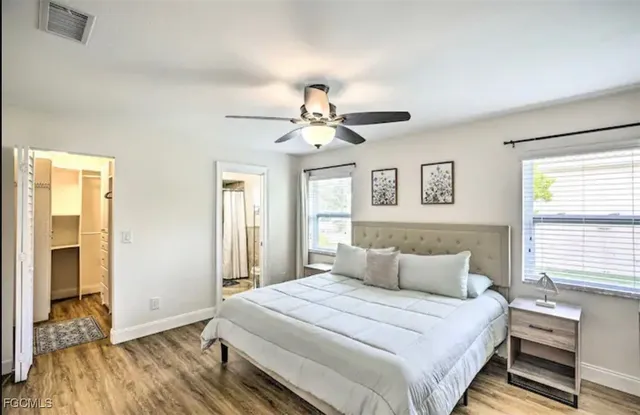 a bedroom with a large bed chandelier and a window