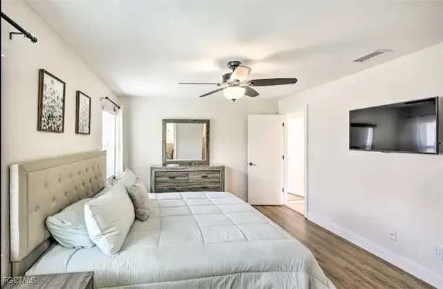 a spacious bedroom with a large bed and a flat screen tv