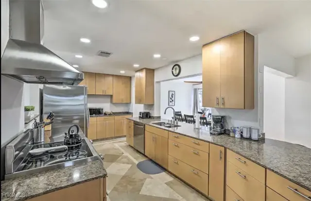 a kitchen with a sink stainless steel appliances and cabinets