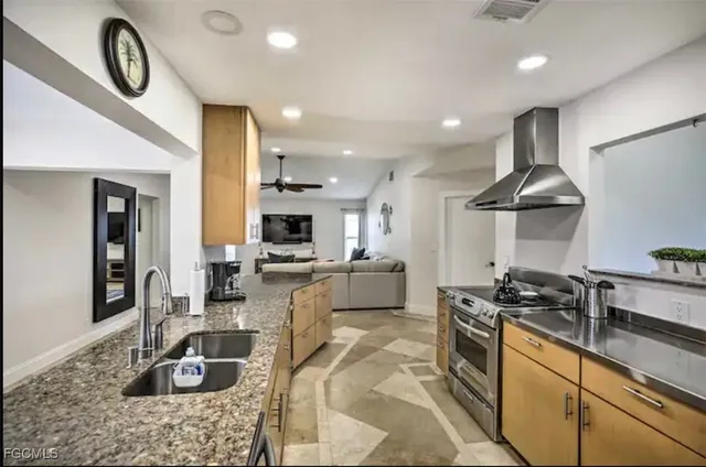 a kitchen with stainless steel appliances granite countertop a sink stove and refrigerator