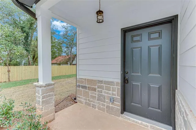 a kitchen with stainless steel appliances kitchen island granite countertop a refrigerator a sink a stove and white cabinets with wooden floor