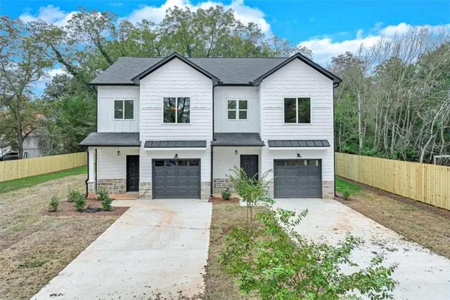 a view of a yard in front of a house with large windows
