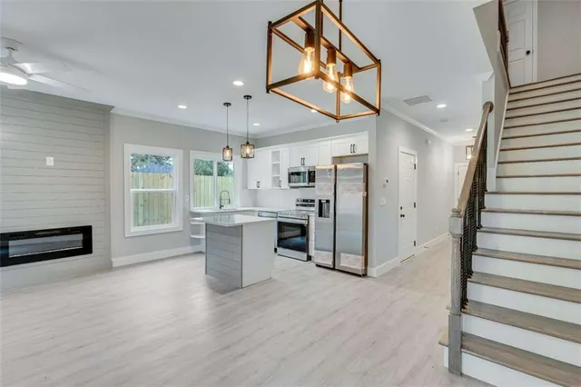 an empty room with wooden floor and ceiling fan
