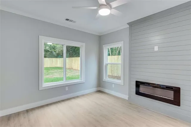 an empty room with a window and a fan