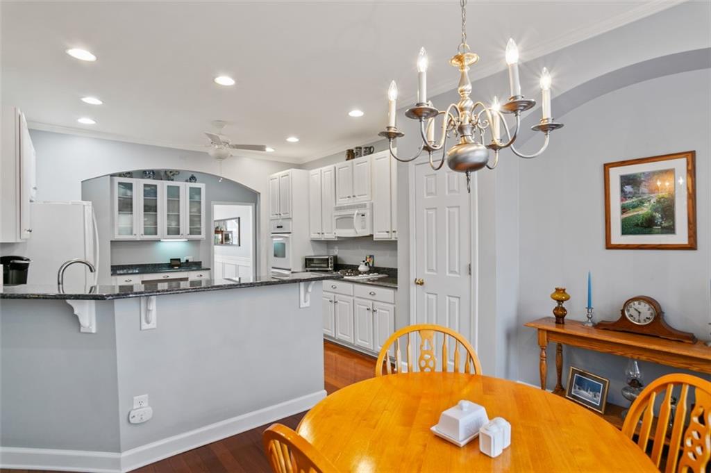 352 Woodbrook Crest Canton, GA 30114 - Photo 15 of 53 a kitchen with stainless steel appliances kitchen island granite countertop a dining table chairs and granite counter tops