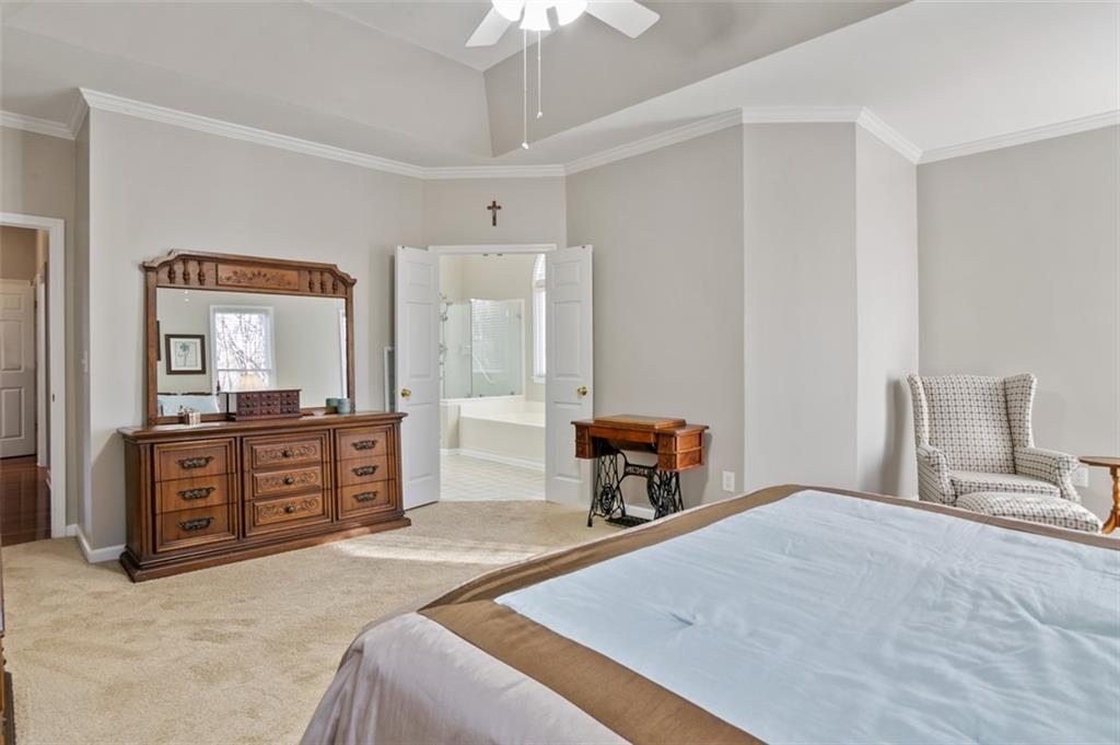 352 Woodbrook Crest Canton, GA 30114 - Photo 18 of 53 a bedroom with a large bed and a chandelier