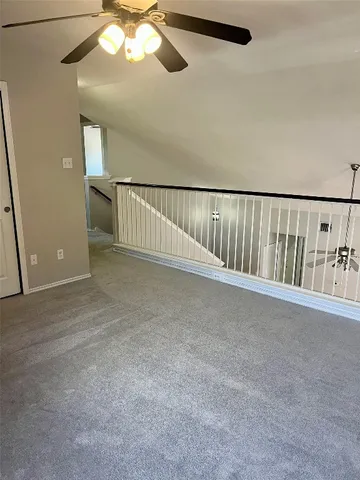 an empty room with windows and ceiling fan