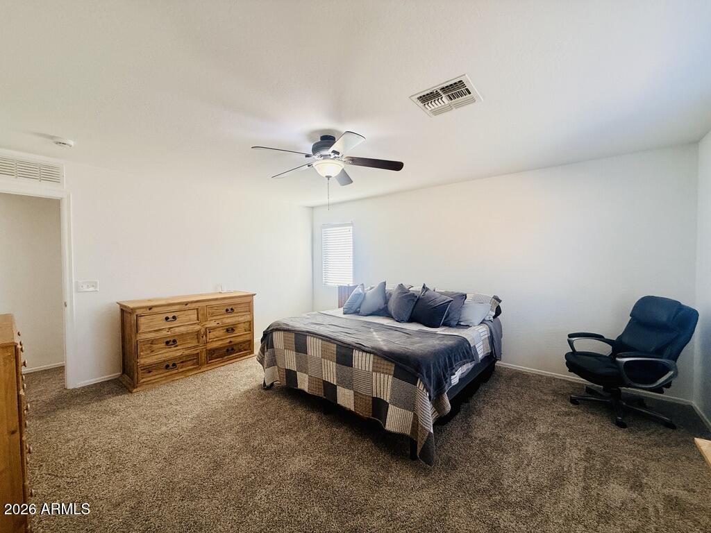 16246 West Boca Raton Road Surprise, AZ 85379 - Photo 18 of 27 a living room with a bed furniture and a ceiling fan