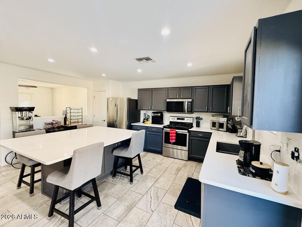 16246 West Boca Raton Road Surprise, AZ 85379 - Photo 6 of 27 a kitchen with a sink a stove a refrigerator and white cabinets with wooden floor