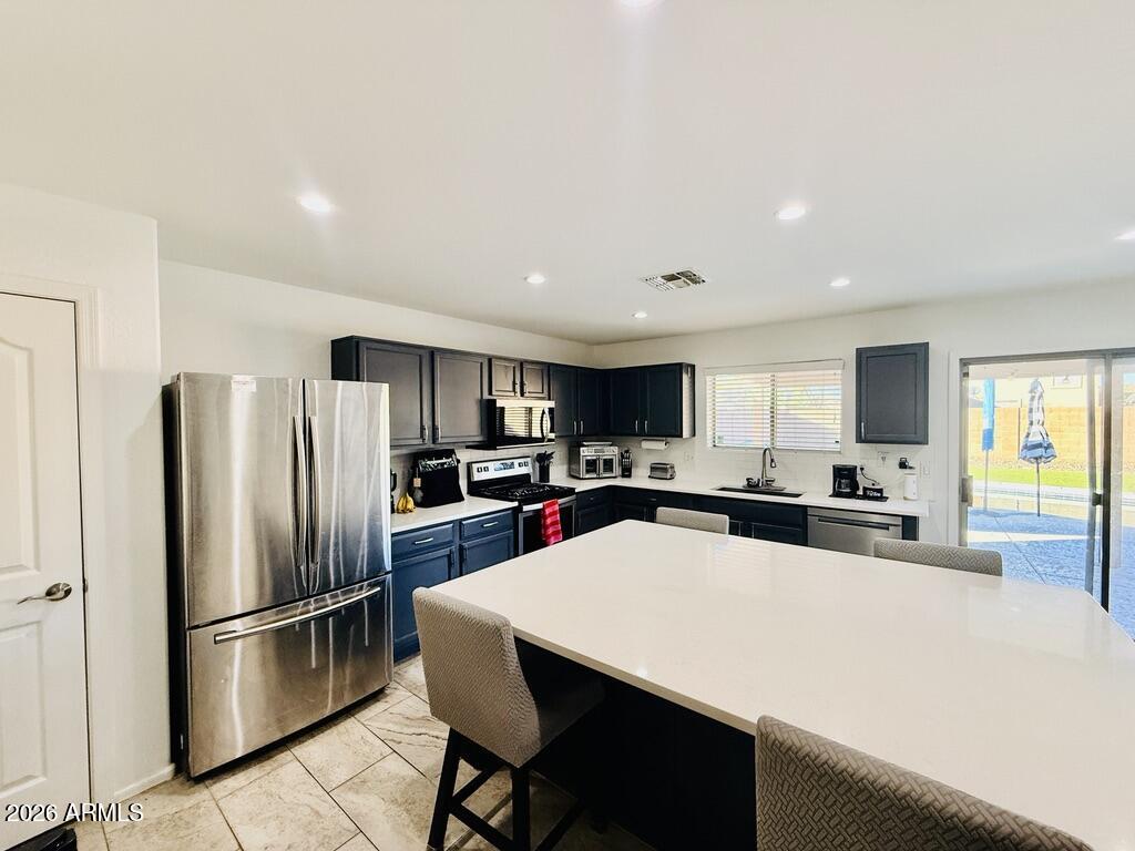 16246 West Boca Raton Road Surprise, AZ 85379 - Photo 8 of 27 a kitchen with stainless steel appliances a refrigerator stove microwave and cabinets