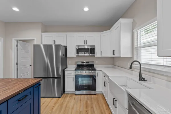a kitchen with a refrigerator sink and wooden floor