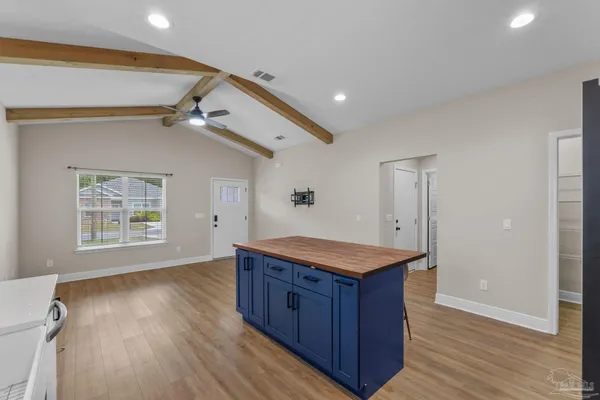 a kitchen with a stove and wooden floor