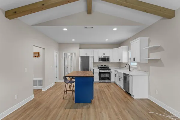 a kitchen with stainless steel appliances kitchen island granite countertop a stove a sink and a refrigerator