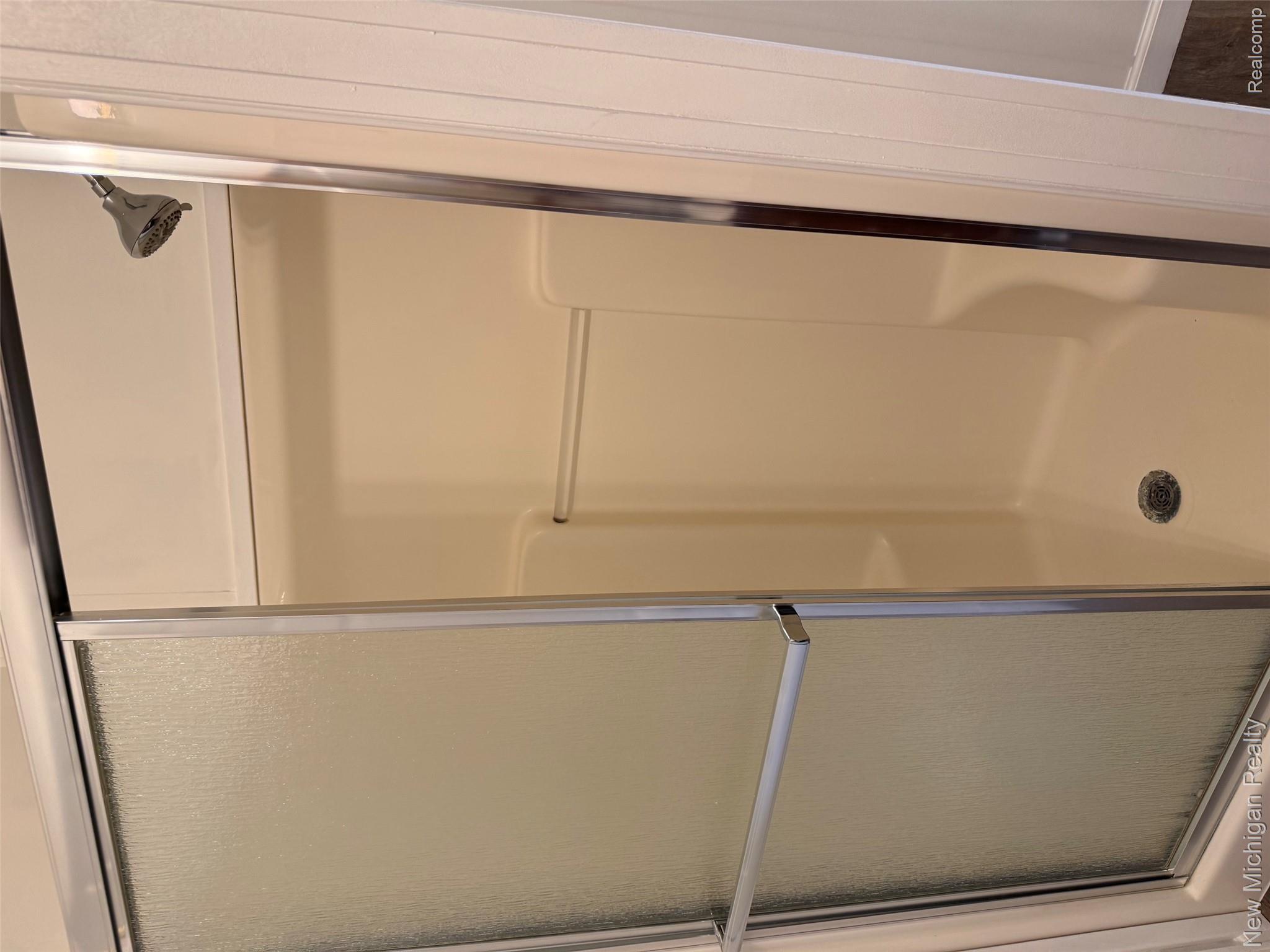 1446 Wheeler Road Allenton, MI 48002 - Photo 16 of 22 Shower enclosure with a textured glass sliding door and chrome hardware