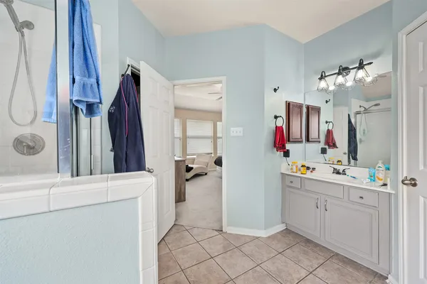 a view of bathroom with a sink mirror and shower