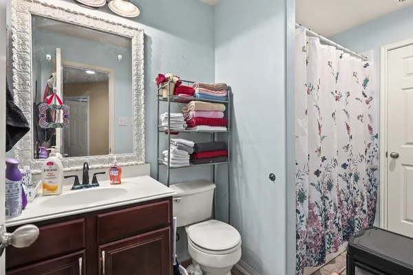 a bathroom with a sink toilet vanity and shower