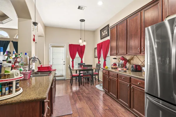 a kitchen with stainless steel appliances granite countertop a refrigerator and stove top oven