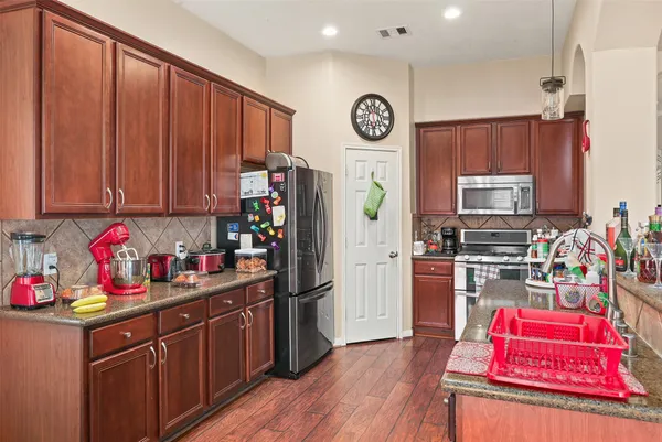a kitchen with granite countertop wooden cabinets and stainless steel appliances
