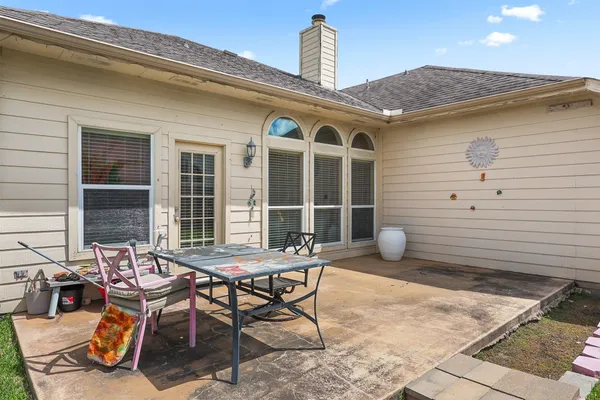 a backyard of a house with table and chairs