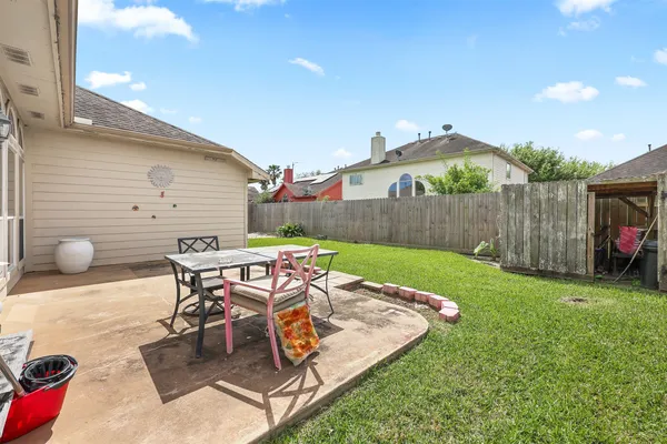 a view of a backyard with table and chairs with wooden fence