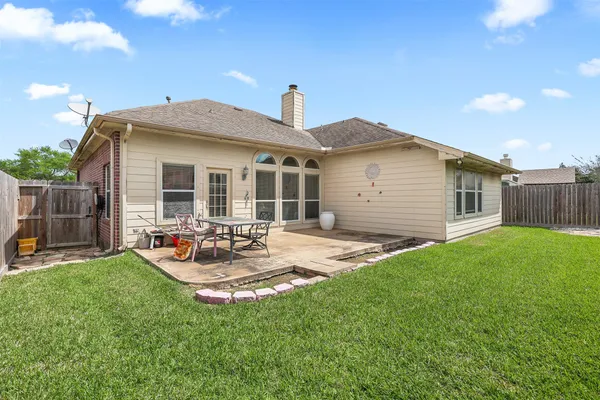 a view of a house with backyard and sitting area