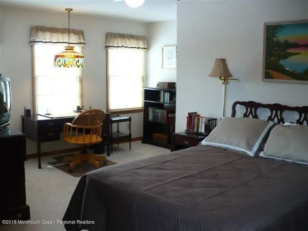 a bedroom with a bed and large windows