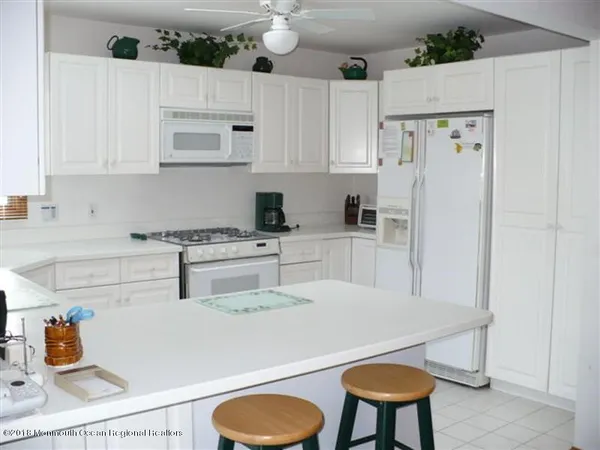 a kitchen with stainless steel appliances granite countertop a refrigerator sink and white cabinets