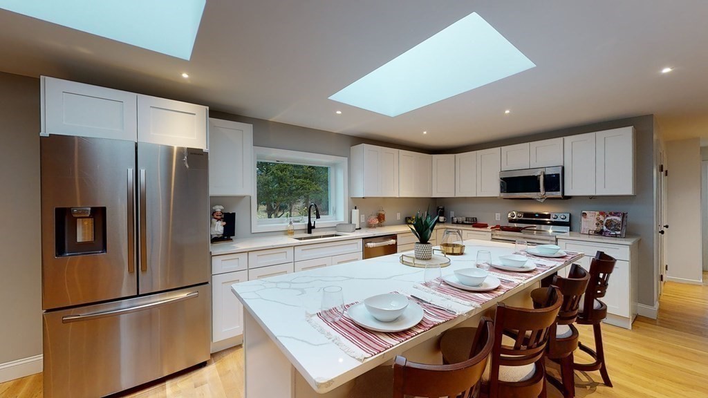 4 Sunset Drive Walpole, MA 02081 - Photo 1 of 37 a kitchen with a refrigerator a stove and a dining table with wooden floor