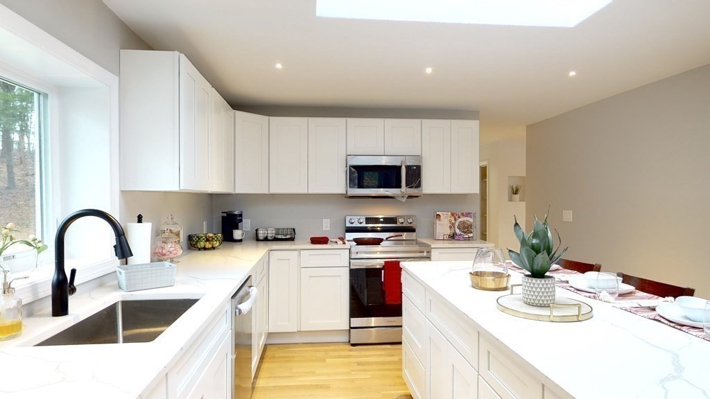 4 Sunset Drive Walpole, MA 02081 - Photo 6 of 37 a kitchen with stainless steel appliances granite countertop a sink a stove a microwave and a refrigerator