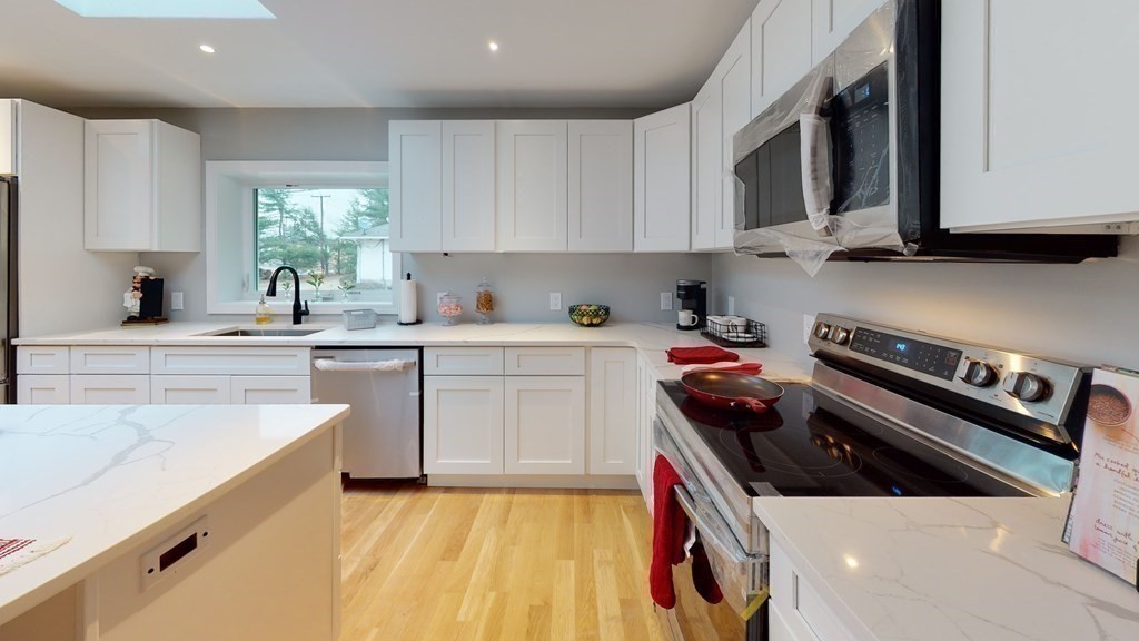 4 Sunset Drive Walpole, MA 02081 - Photo 8 of 37 a kitchen with stainless steel appliances a sink dishwasher a stove and a microwave