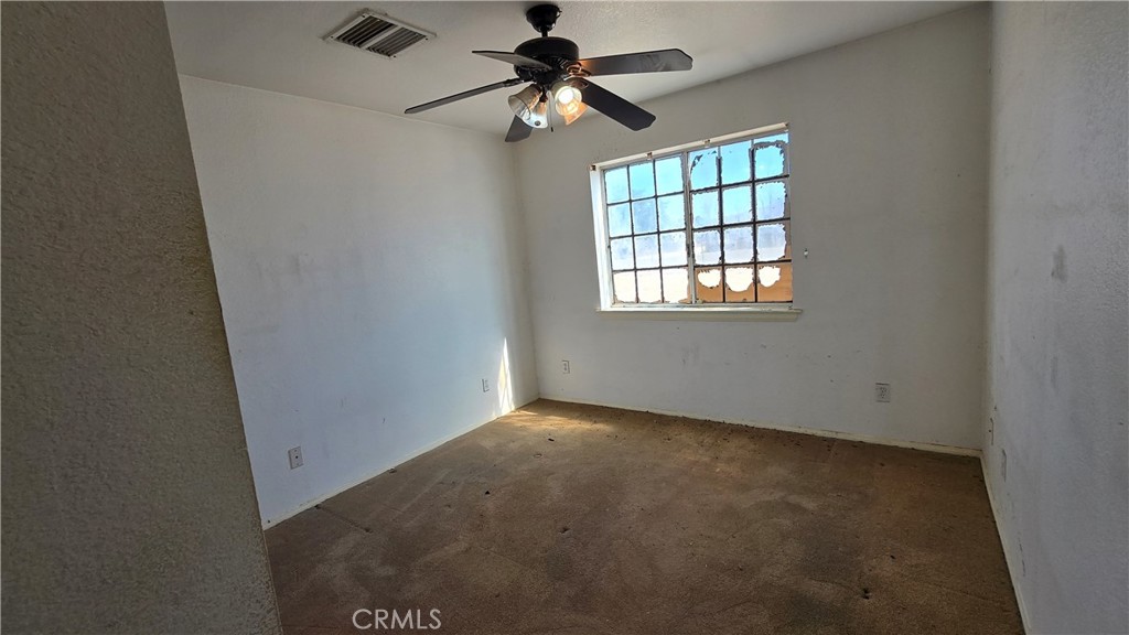 14280 Navajo Road Apple Valley, CA 92307 - Photo 12 of 28 an empty room with windows and fan