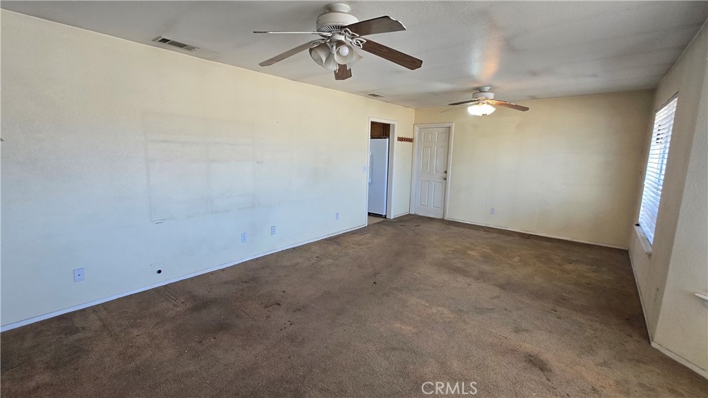 14280 Navajo Road Apple Valley, CA 92307 - Photo 5 of 28 en empty room with ceiling fan and window
