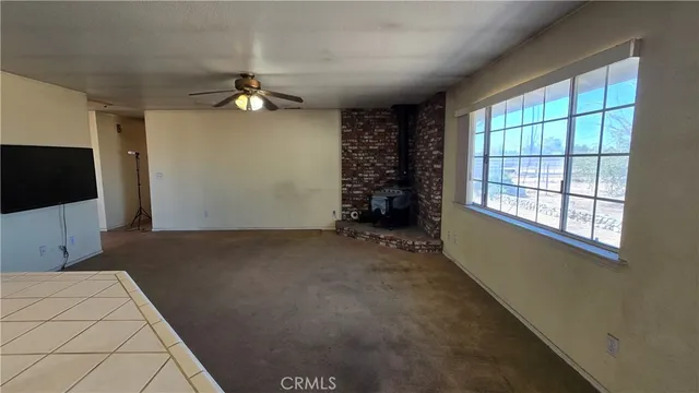 a view of a livingroom with a ceiling fan and window