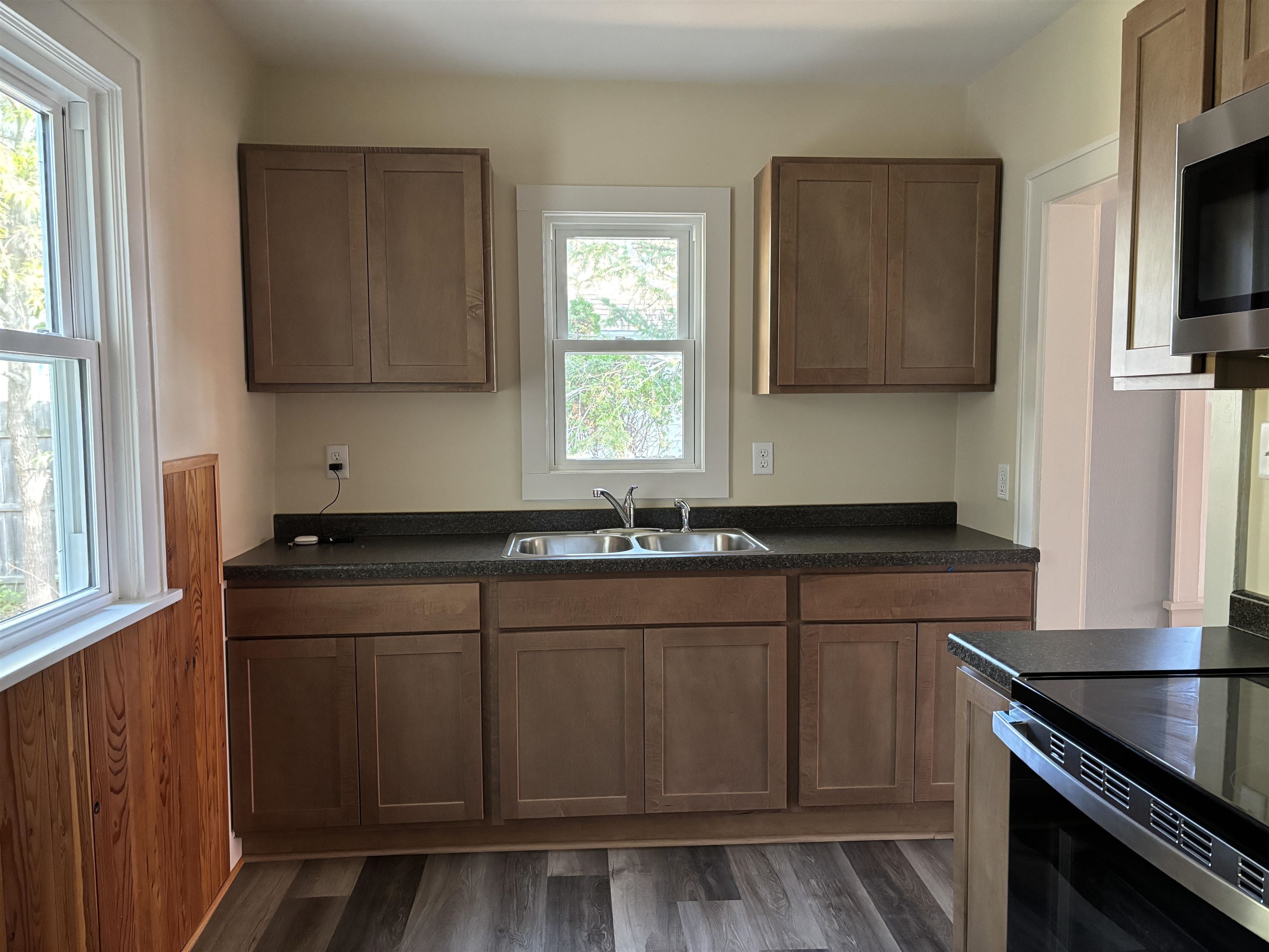 2515 Jefferson Street Duluth, MN 55812 - Photo 14 of 25 Kitchen featuring dark countertops, stainless steel microwave, dark wood finished floors, black range with electric stovetop, and wood walls