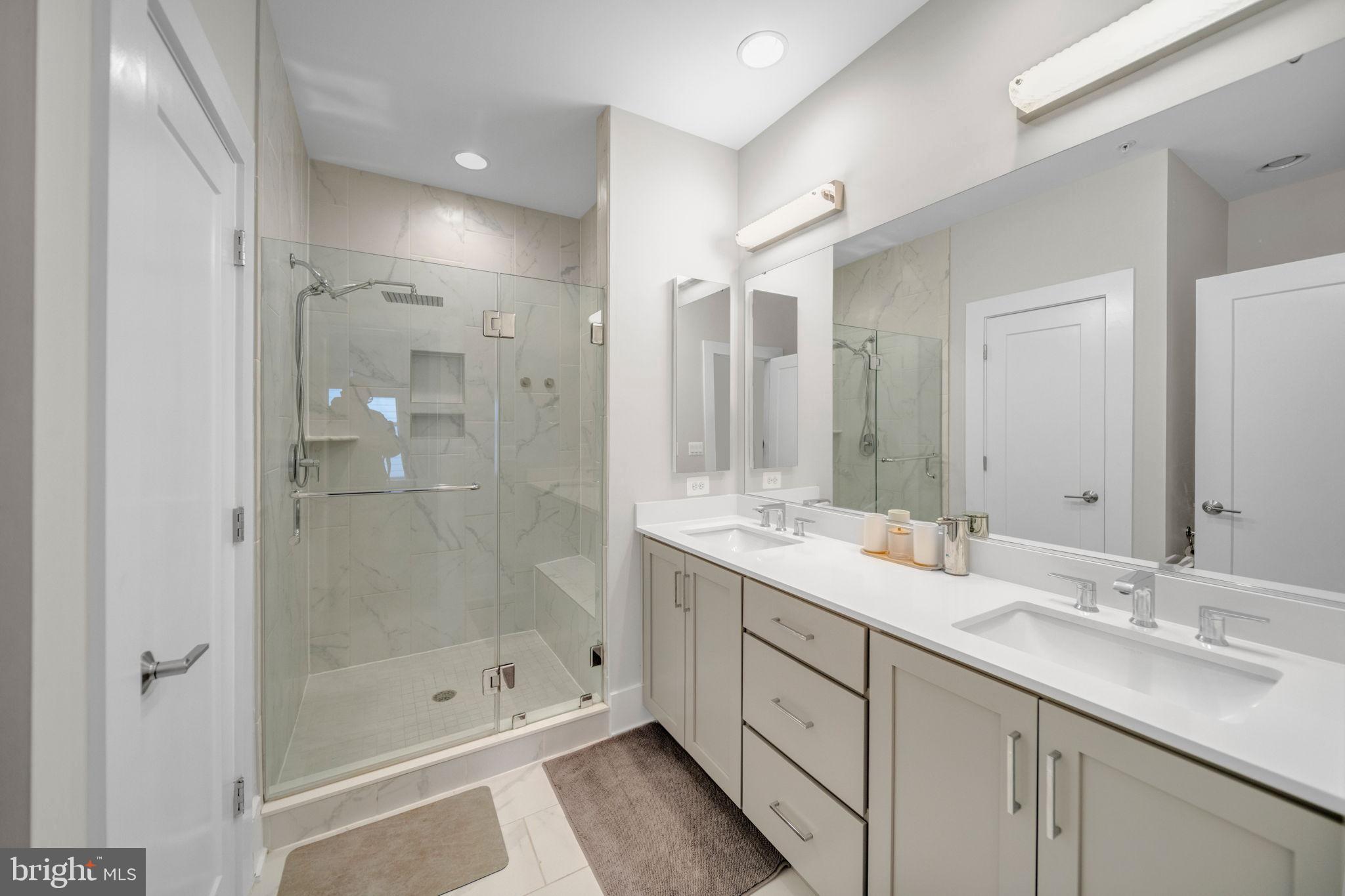 11326 Emerald Park Road Potomac, MD 20854 - Photo 13 of 40 a bathroom with a shower tub double sink and mirror