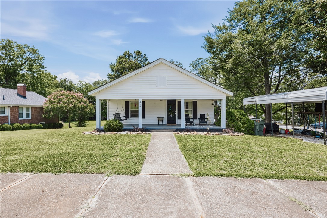 A welcoming front porch, ideal for relaxation, graces this charming single-story residence.