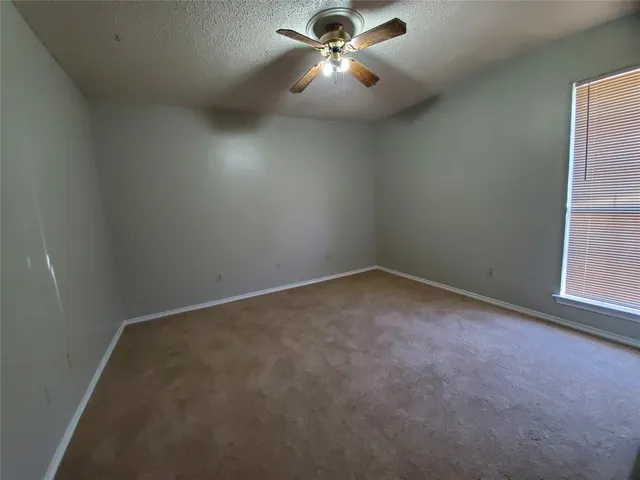 en empty room with windows and fan