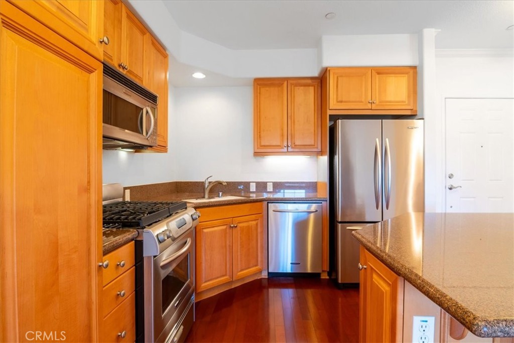 21345 Hawthorne Boulevard, Unit 217 Torrance, CA 90503 - Photo 5 of 41 a kitchen with stainless steel appliances granite countertop a refrigerator a stove and a sink with wooden floor