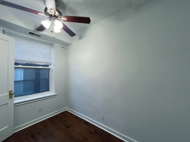 an empty room with a window and wooden floor