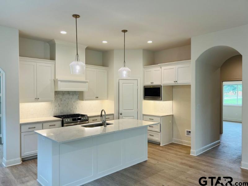 2983 Guinn Farms Road Tyler, TX 75707 - Photo 6 of 22 a kitchen with kitchen island a counter top space a sink stainless steel appliances and cabinets