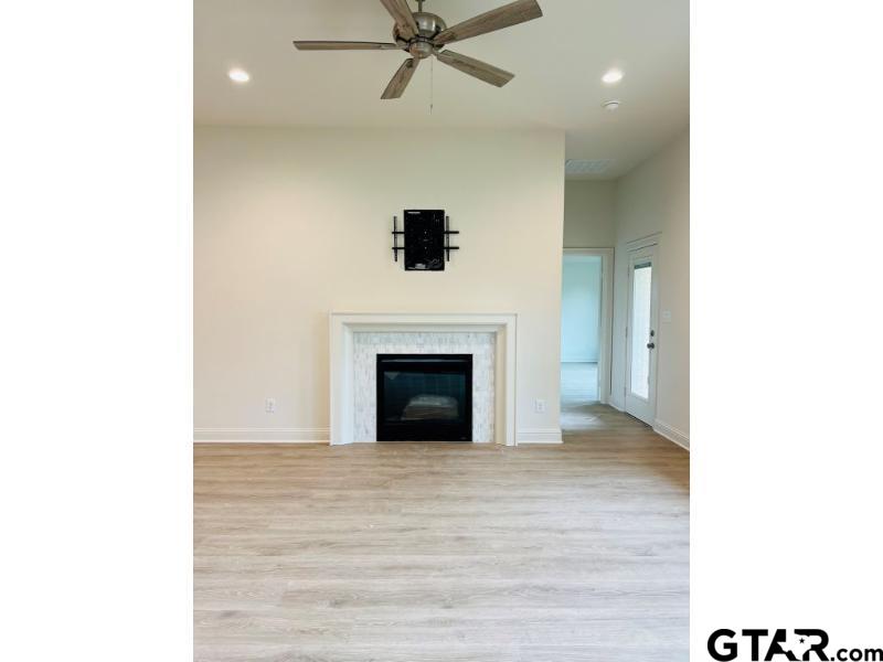 2983 Guinn Farms Road Tyler, TX 75707 - Photo 9 of 22 a view of a livingroom with a fireplace and a ceiling fan