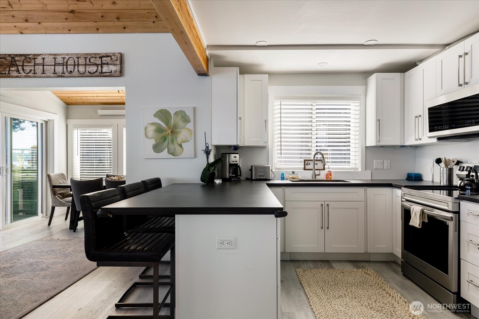 159 South Harrington Lagoon Road Coupeville, WA 98239 - Photo 11 of 37 a kitchen with a stove a sink a microwave and dining table