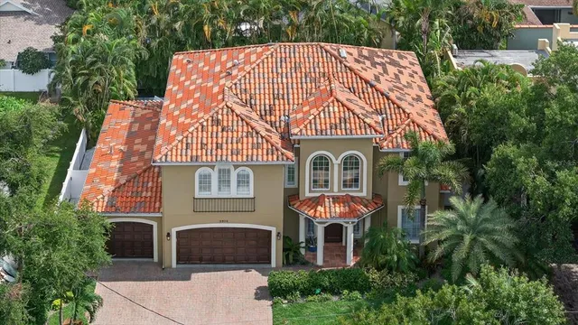 an aerial view of a house with yard and tree s