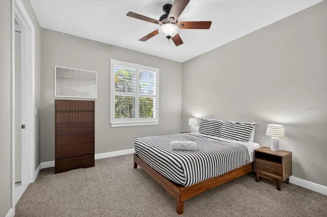 a bedroom with a bed and painting on the wall