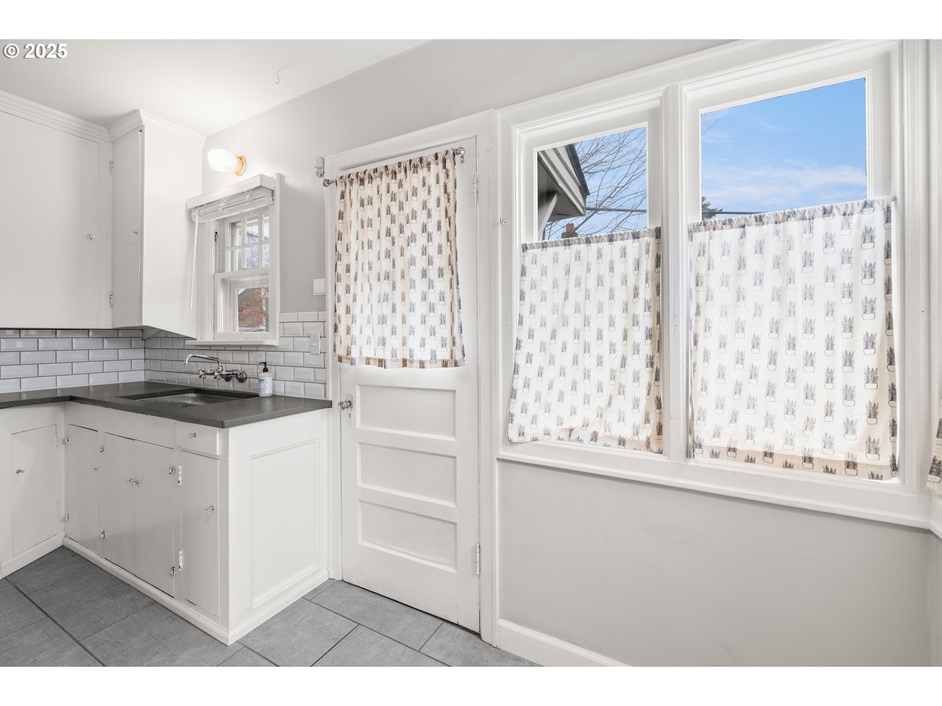 7104 Southeast Tolman Street Portland, OR 97206 - Photo 12 of 34 a kitchen with granite countertop white cabinets and black stainless steel appliances